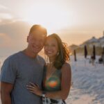 man in gray crew neck t-shirt standing beside woman in green sleeveless dress during daytime