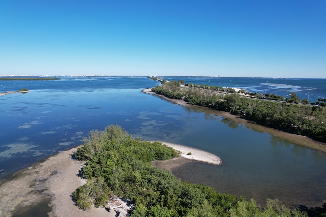 A drone photo of the road and coastline to the Skyway Bridge in Tampa Bay, Florida by Drone photographer Anita Denunzio. by Florida Getaways an aerial view of a body of water