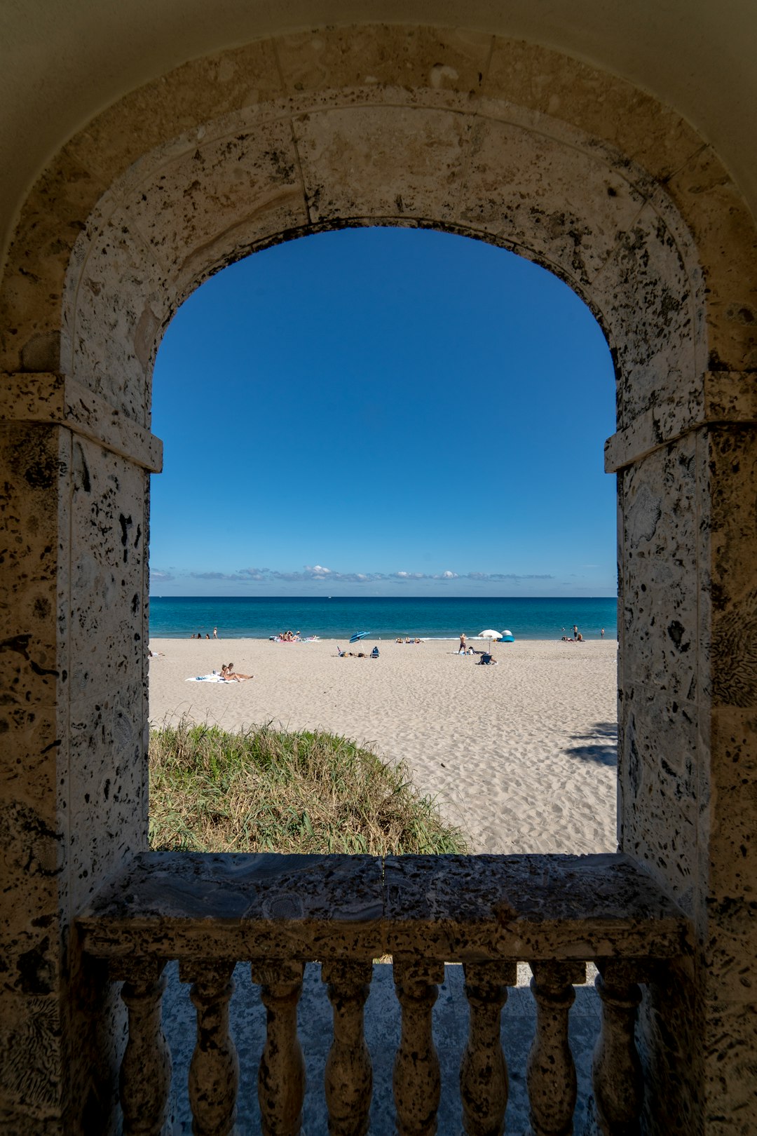 View of a beach through an arched window.