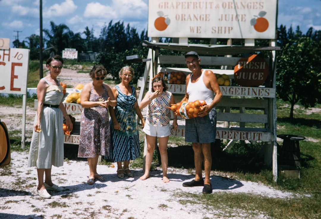 📜 Florida's Family Fun Legacy: A Brief History of Sunshine State Getaways by Florida Getaways a group of people standing in front of a fruit stand