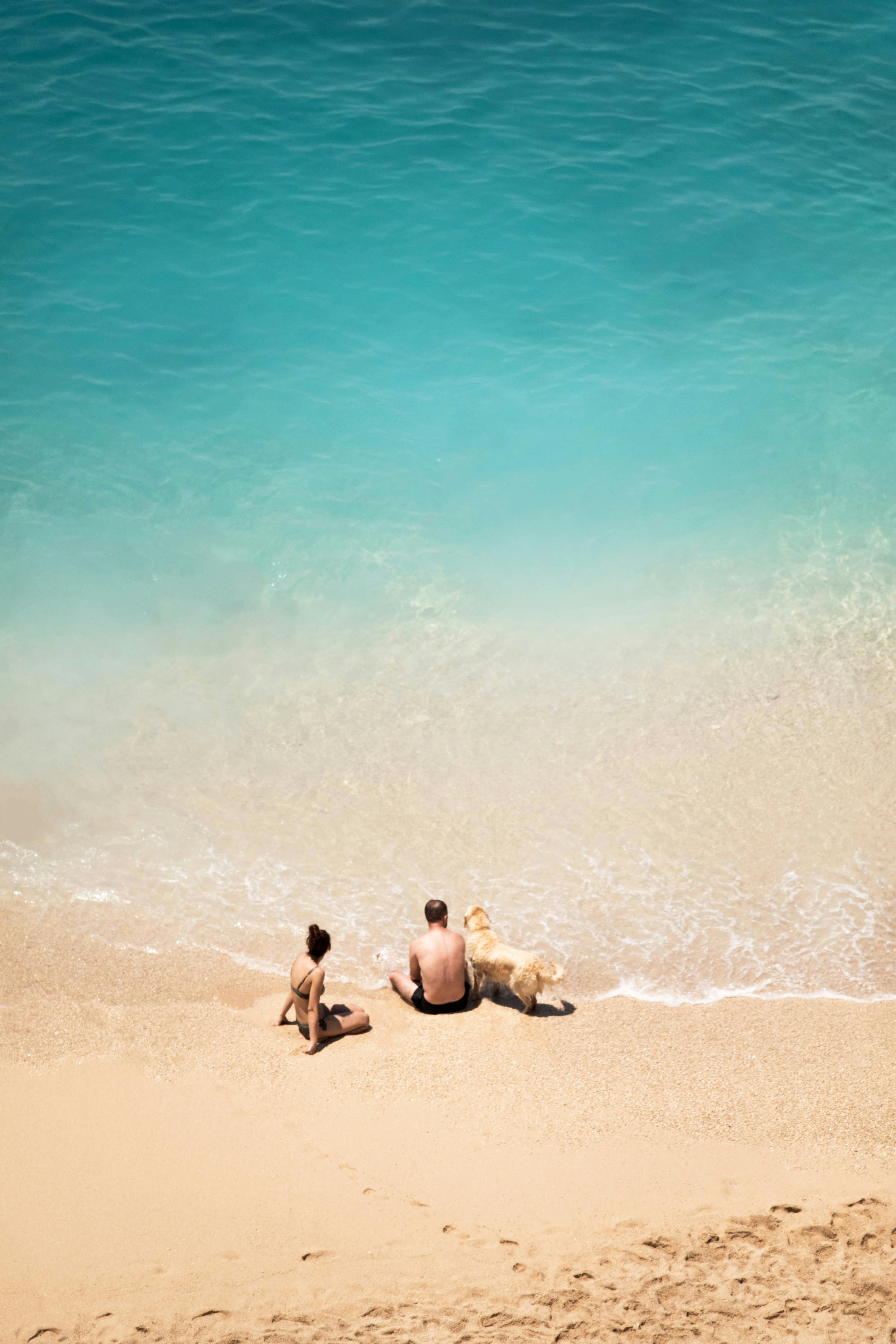 A happy family... by Florida Getaways 2 men sitting on beach during daytime